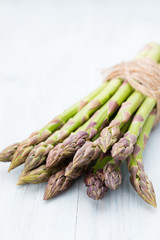 Bunch of fresh asparagus on wooden table.