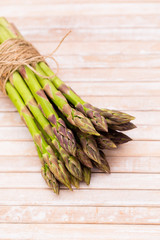 Bunch of fresh asparagus on wooden table.