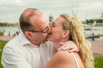 A pair of husband and wife, relaxing in the Park and kiss.