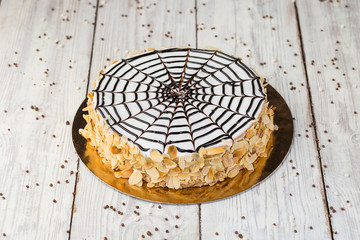 Dark chocolate vegan cake with candies and nuts on wooden background