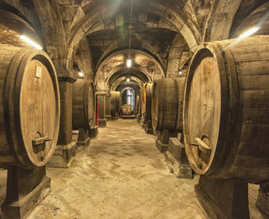 Old wooden barrels with wine in a wine vault