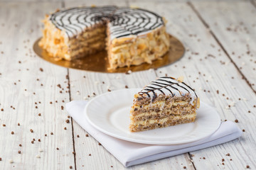 Dark chocolate vegan cake with candies and nuts on wooden background