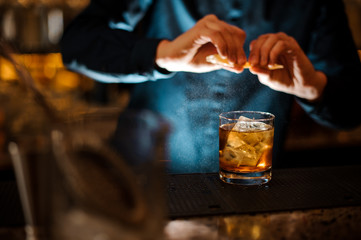 Brunet bartender adding a fresh orange juice to the cocktail