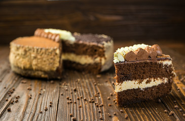 Fototapeta na wymiar Dark chocolate vegan cake with candies and nuts on wooden background