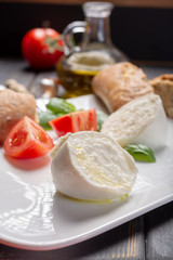 Traditional italian food - white ball mozzarella buffalo Italian soft cheese with cheese knife, tomato, basil, olive oil