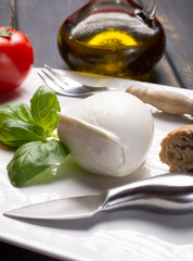 Traditional italian food - white ball mozzarella buffalo Italian soft cheese with cheese knife, tomato, basil, olive oil