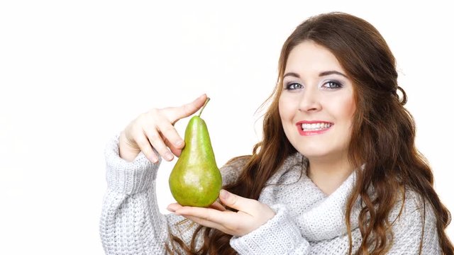 Woman wearing warm clothing sweater holding green pear fruit, isolated on white. Healthy eating, vitamins immunity in cold winter time concept.
