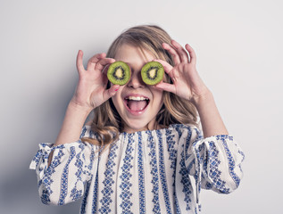 A Beautiful girl child holding kiwi in studio white
