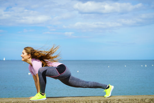 Woman stretching legs next to sea