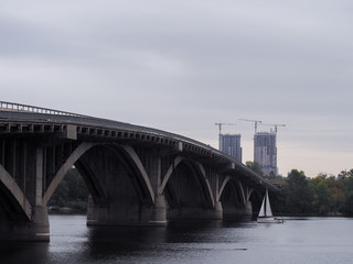 Fototapeta na wymiar Boat at the river crossing the bridge