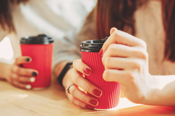 Women enjoy having cup of coffee at cafe together
