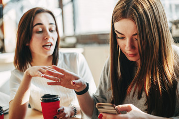 Woman trying to speak to her inattentive friend