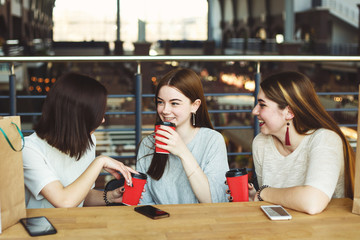 Young women drinking coffee at cafe in the mall