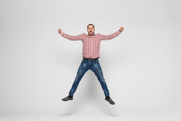 happiness, freedom, movement and people concept - smiling young man jumping in air isolated on white background