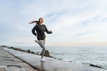 confident inspired girl runner actively trains in the open air, prepares for a marathon
