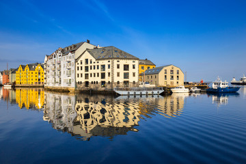 Obraz premium Architecture of Alesund town reflected in the marina canal, Norway
