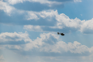 Helicopter am Himmel mit dicken Wolken, Dicke Wolken und blauer Himmel, schöne große Wolken und Hubschrauber
