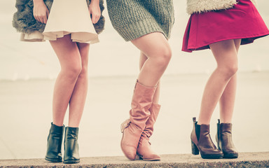 Three women presenting shoes outdoor