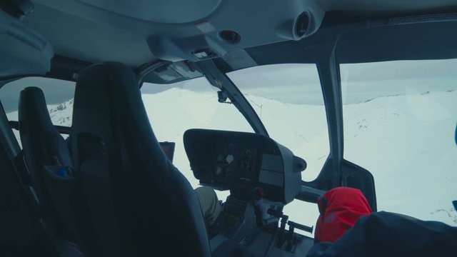 POV from the inside of a helicopter flying over snow mountains