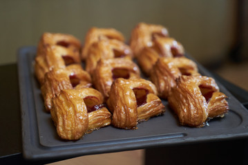 Puff pastry with jam on a tray in a bakery shop, close-up