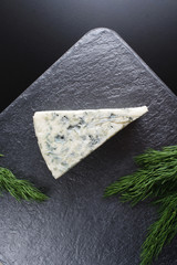 blue cheeseon a dark stone background