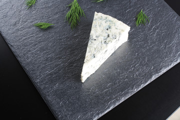 blue cheeseon a dark stone background