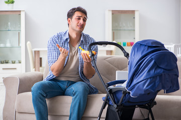 Young father looking after newborn baby at home