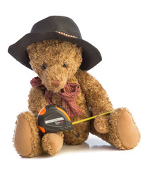 Teddy bear sitting  with a meter and a black hat