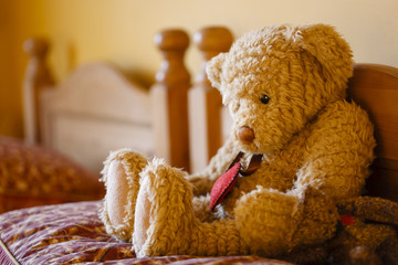 Sad teddy bear on a bed