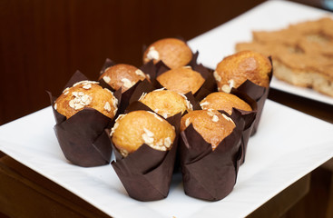 Freshly cupcakes on a white cake board plate, close-up. Delicious dessert