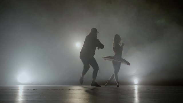 Contemporary dance battle between a street dancer versus a young beautiful ballerina