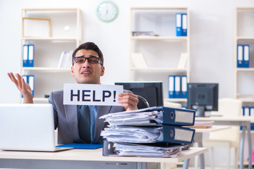 Businessman workaholic struggling with pile of paperwork