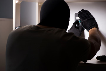 Burglar wearing balaclava mask at crime scene