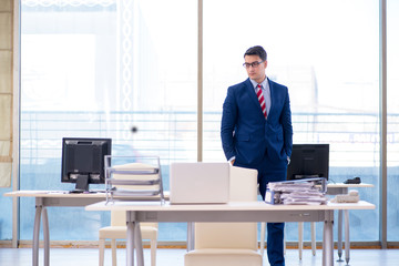 Young handsome businessman employee working in office at desk