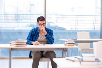 Student studying in the empty library with book preparing for ex