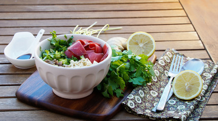 Pho soup -  Vietnamese noodle soup with broth, linguine-shaped rice noodles, cilantro and beef