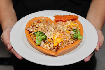 Sausage cheese in heart style wrap fried rice with pork  topped carrot and Broccoli on white plate.