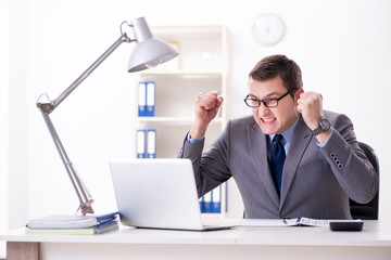 Young handsome businessman employee working in office at desk