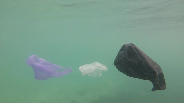 Plastic pollution in ocean environmental problem. Platic bags, bottles cups and straws dumped in sea