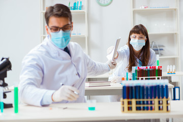 Two chemists working in lab experimenting