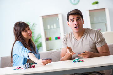 Young family playing cards at home