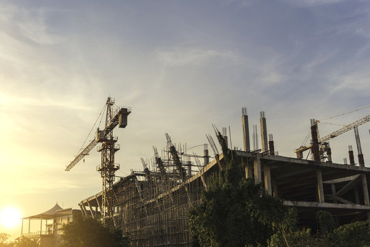 Tower crane with building structure under construction  with sunset