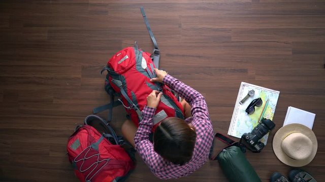 Overhead view of traveler woman plan and backpack travel planning vacation trip. Top view slow motion