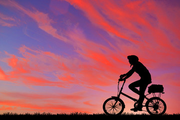 Fototapeta premium Silhouette man and bike relaxing on sunrise