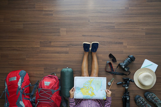 Overhead view of traveler woman plan and backpack planning vacation trip with map. Top view.