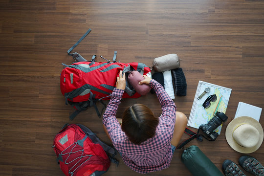 Overhead view of traveler woman plan and backpack planning vacation trip with map. Top view.