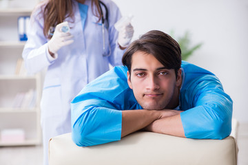 Obraz premium Funny man getting ready for buttocks syringe shot