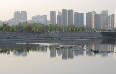 Fototapeta na wymiar Air pollution with city skyline reflection in the river
