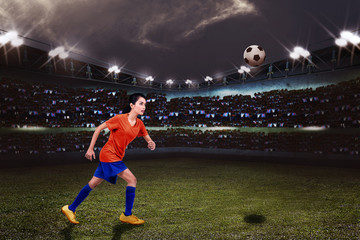Naklejka premium Young asian female footballer want to kicking the ball