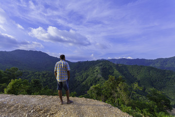 Naklejka premium a man standing on hilltop look around the valley